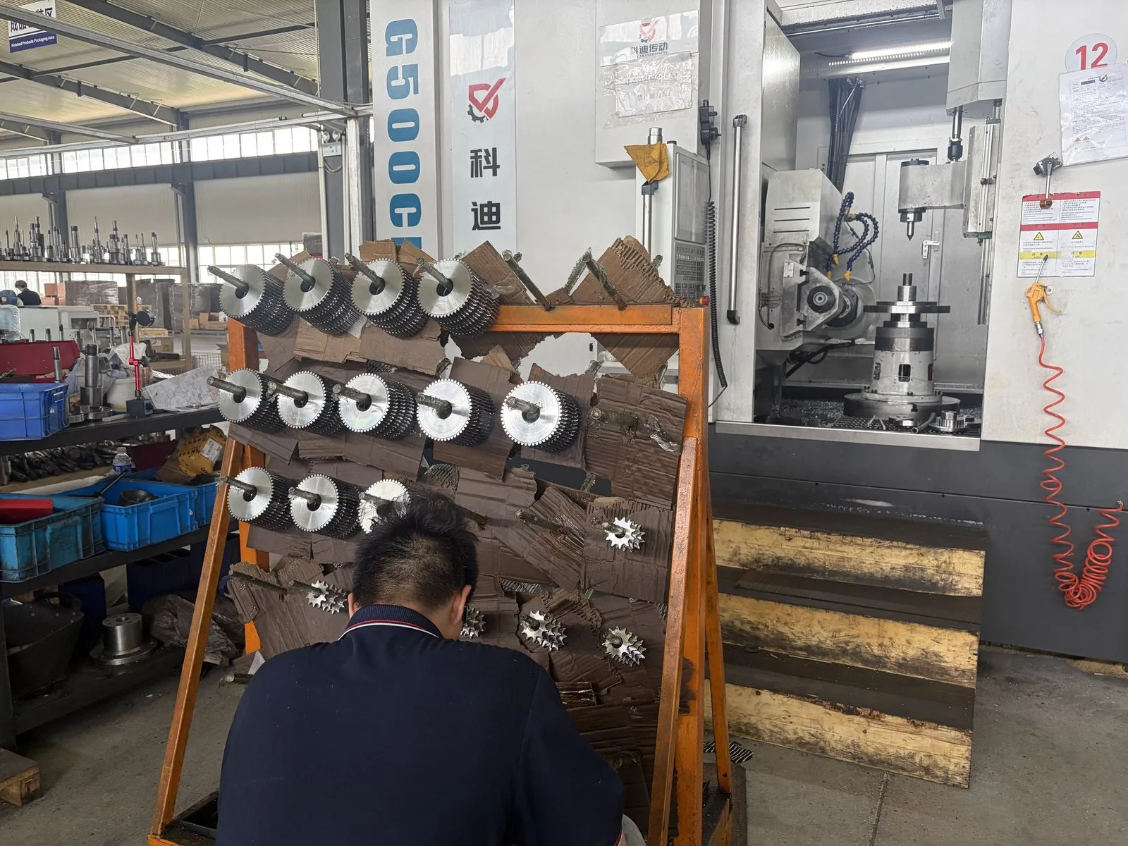 CNC gear hobbing machine with a rack of finished sprockets